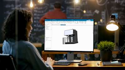 Engineer building an espresso machine in NX CAD software.