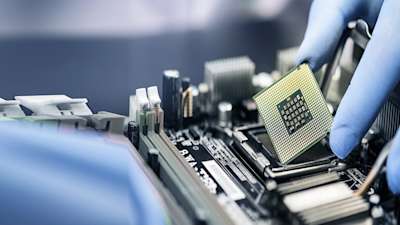 Image of gloved hands holding a chip. 