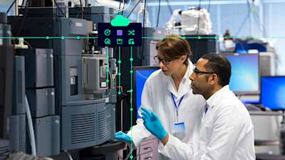 a women in a lab is inspecting work with her tablet.