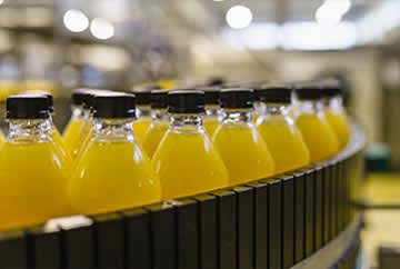 Bottles moving through assembly line in industrial processing facility