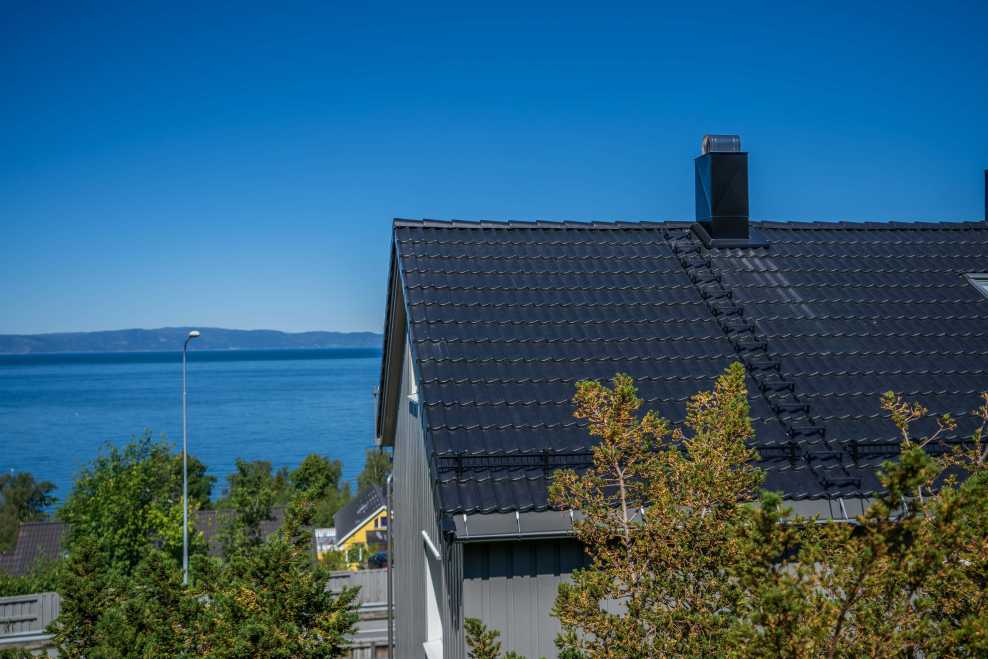 Hus ved kysten med Protector sort på taket