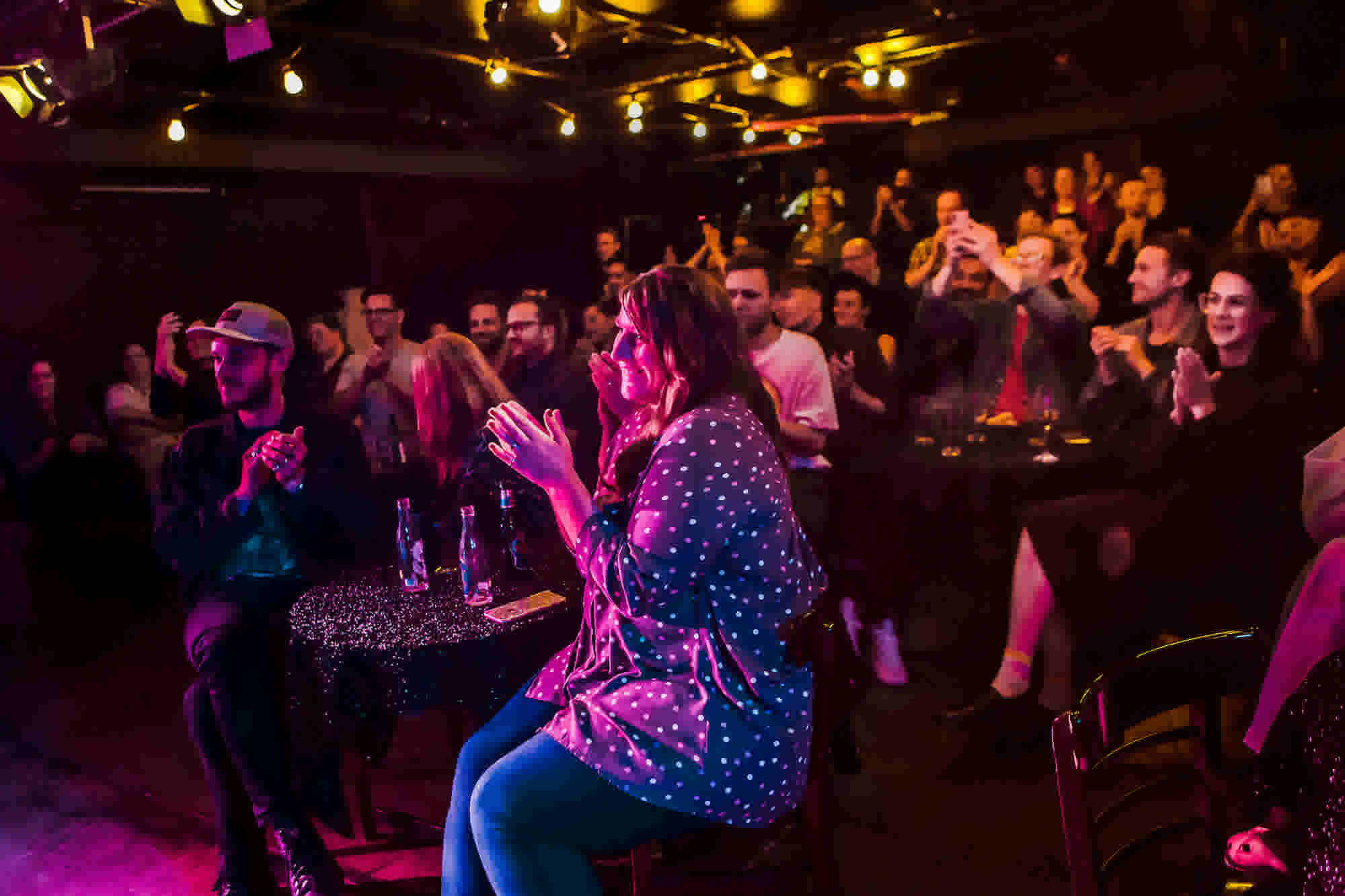 A crowd of people applauding during a Basement Theatre event. 