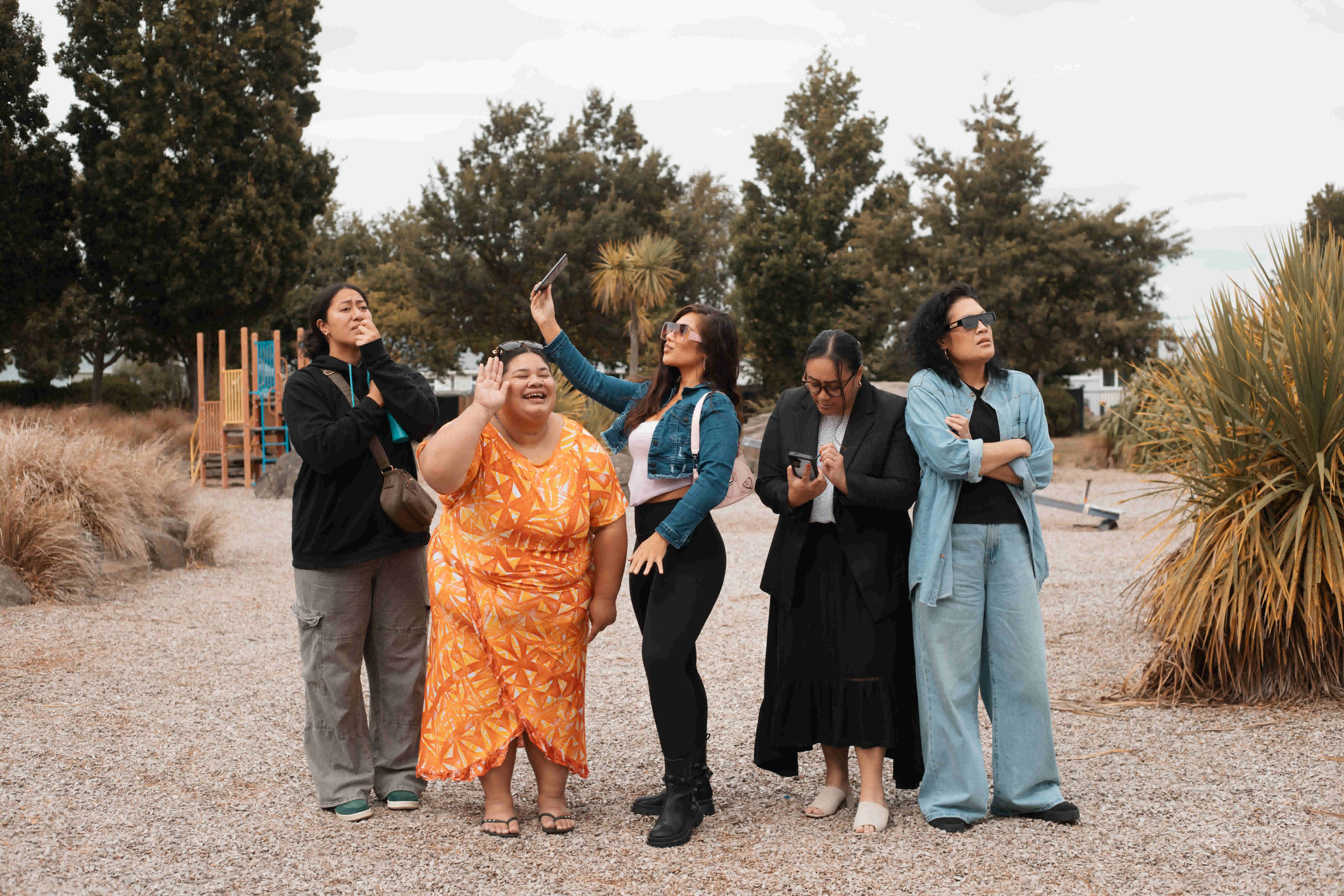 Five wahine stand side by side in a playground