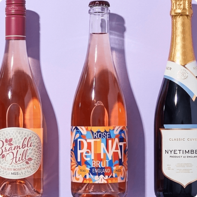 Three bottles of English wine on a purple background