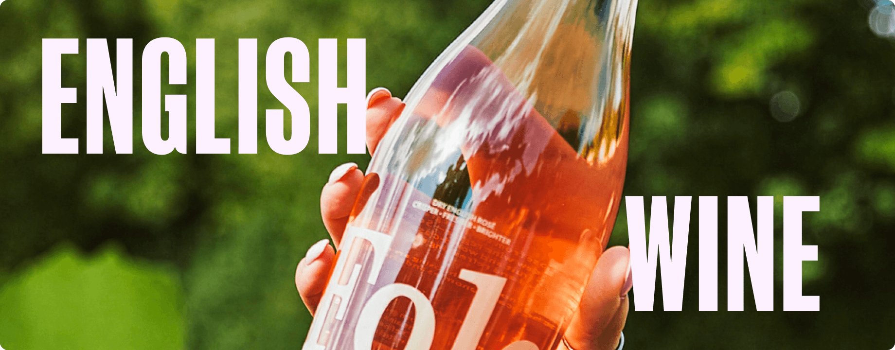 Hand pouring a glass of English rose wine outdoors