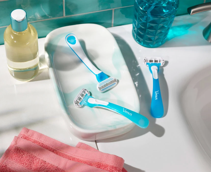 Three blue razors on a bathroom sink