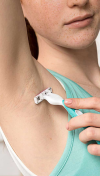 Woman shaving her underarm area with a razor