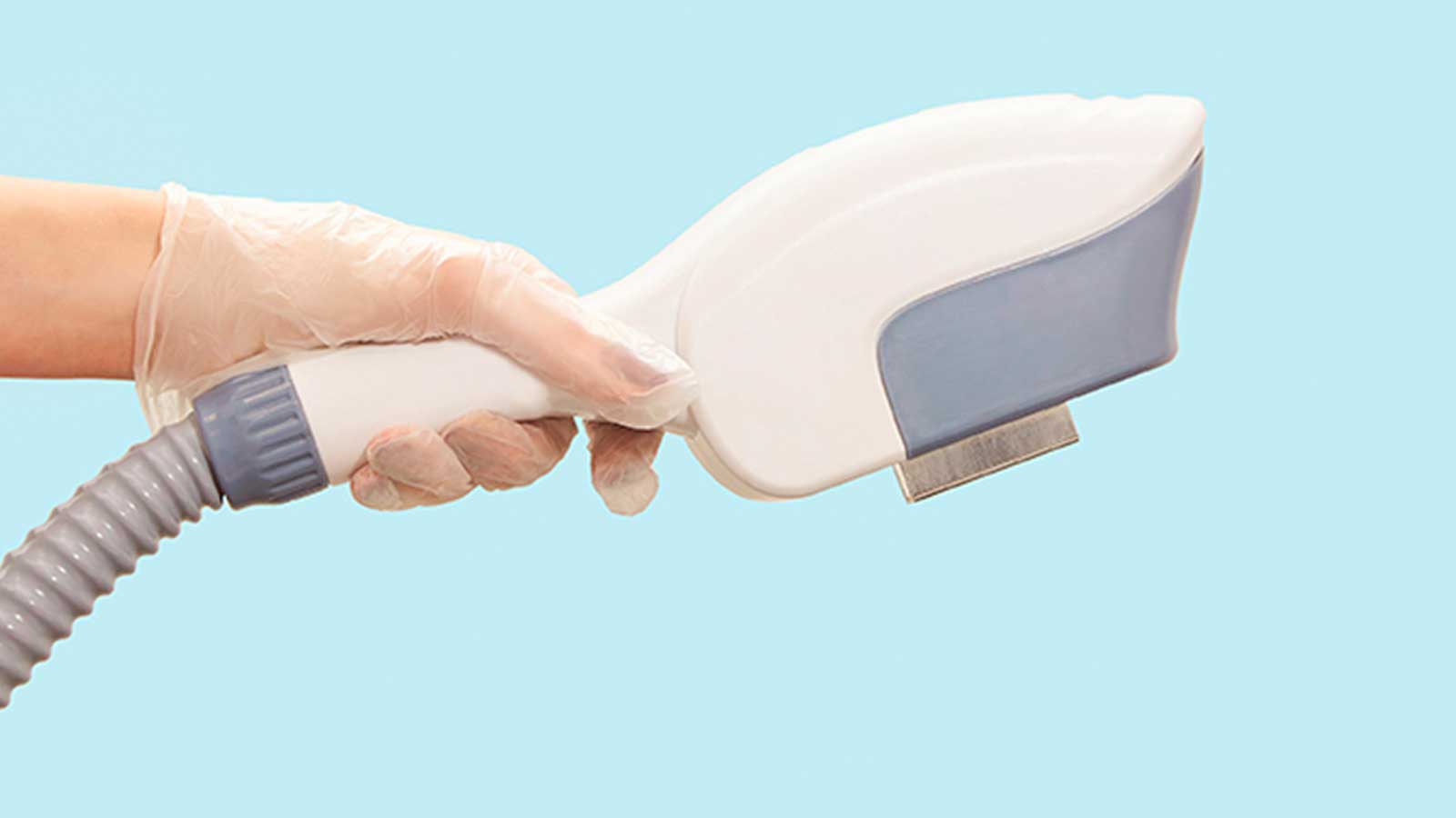 Female hand in a glove holding an IPL epilation machine