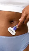 Woman shaving her belly area with a razor