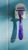 Razor on a razor rack attached to a bathroom wall