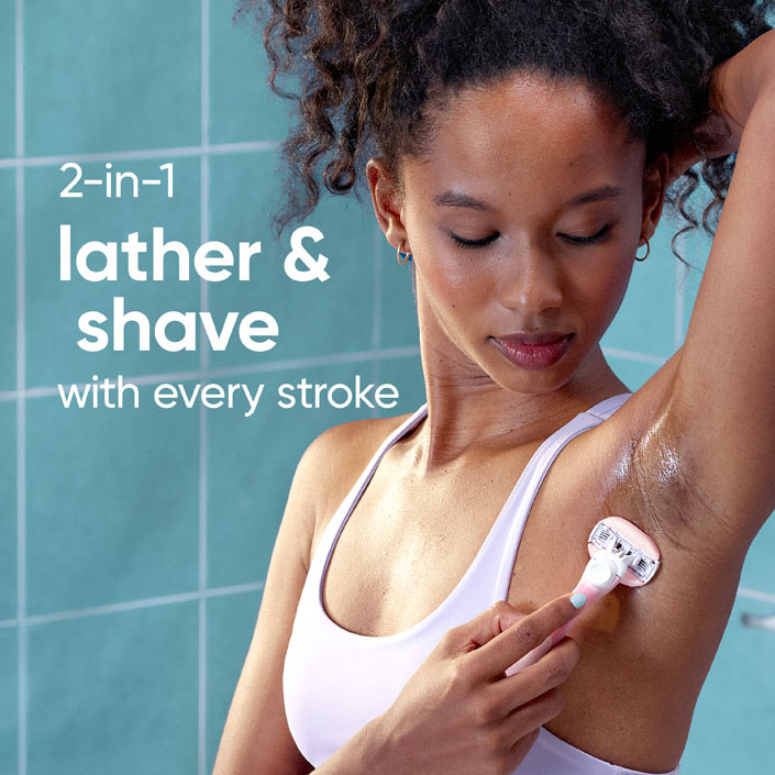 Young lady shaving her armpit in the bathroom, using Venus ComfortGlide White Tea Razor.