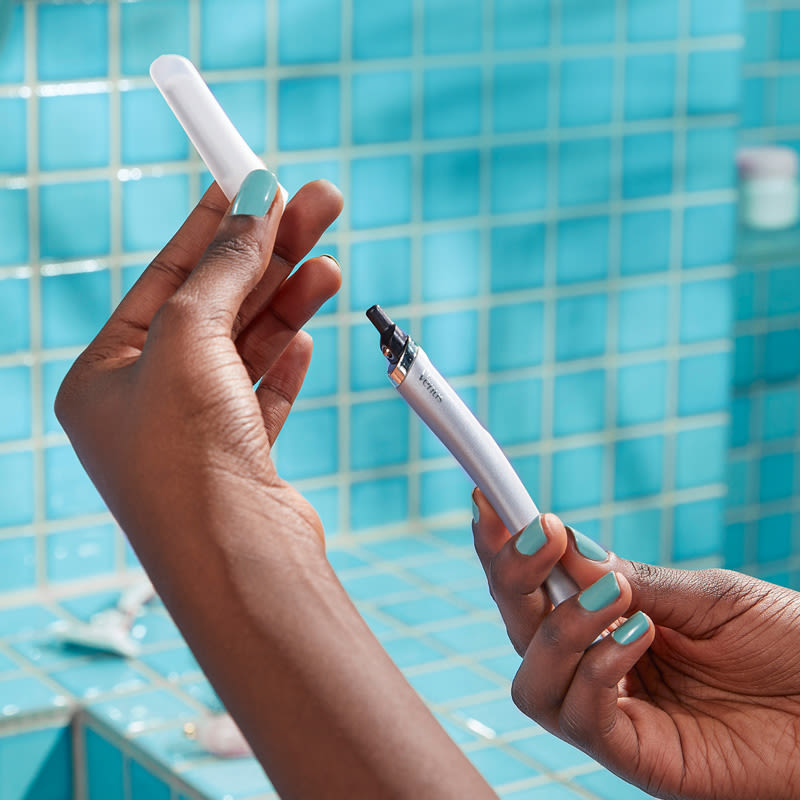 Close-up shot of two hands demonstrating how to change the blade on the Venus Facial razor.