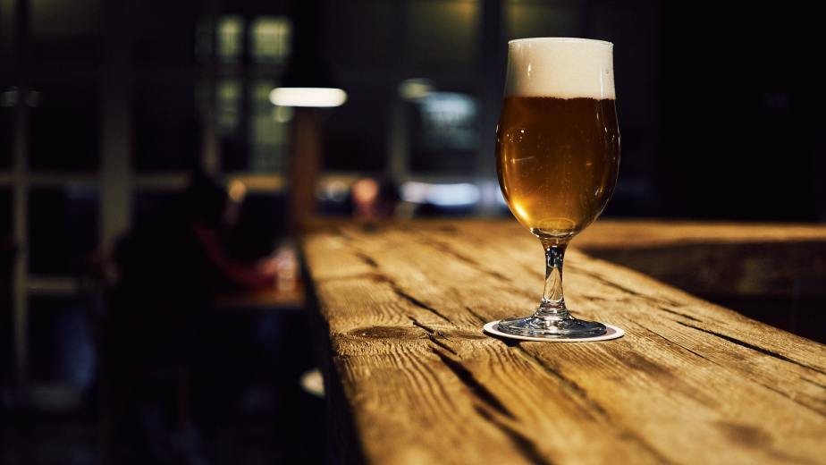 Gevuld bierglas op een bierviltje. (van mnm.all via Unsplash)