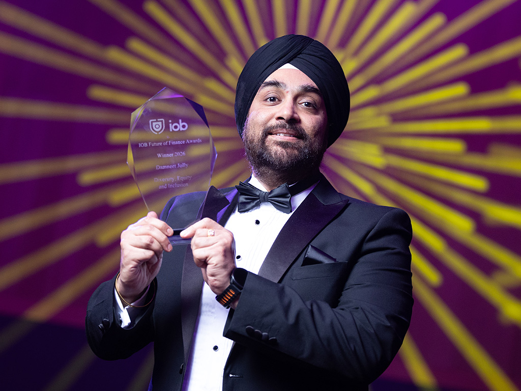 Photo of Damneet Jolly holding an award.