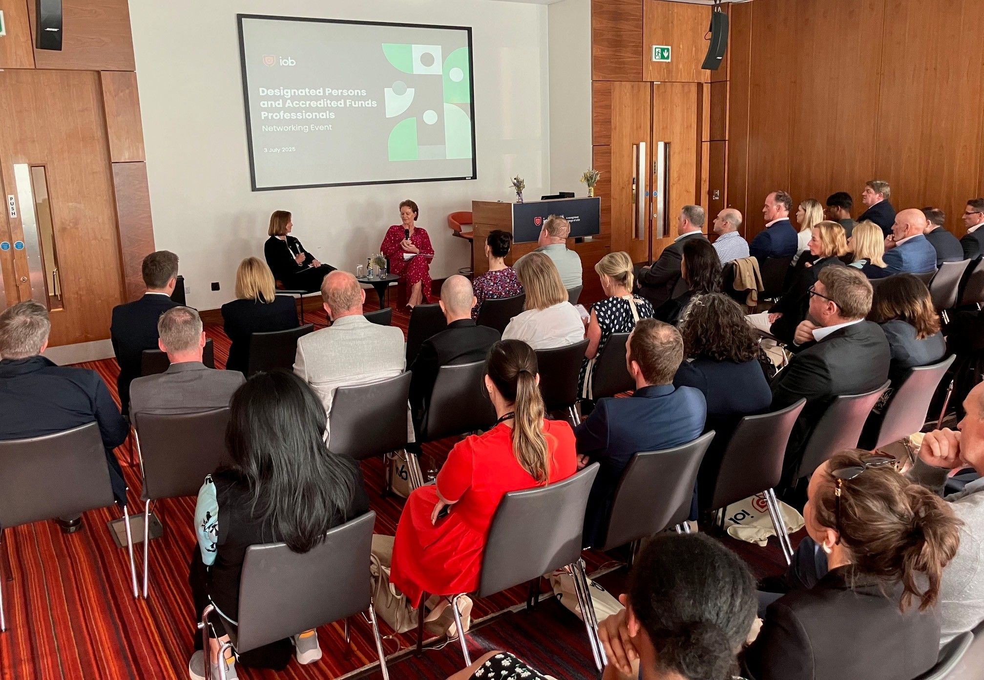 A panel discussion with a group of people sitting in chairs.