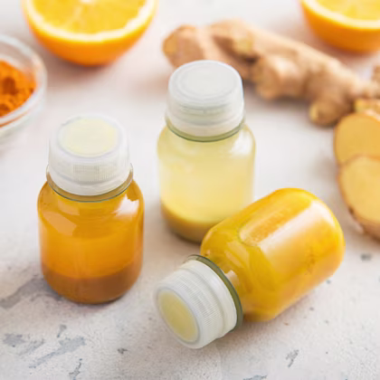 orange wellness shot in glass bottle