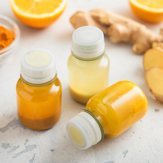 orange wellness shot in glass bottle