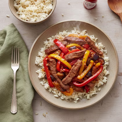 sliced steak and peppers on a bed of rice