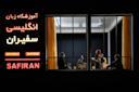 A classroom seen through large windows, with five people seated and one standing, possibly teaching. The bright sign outside reads “SAFIRAN” and lists numbers, along with Persian text indicating it’s an English language school.