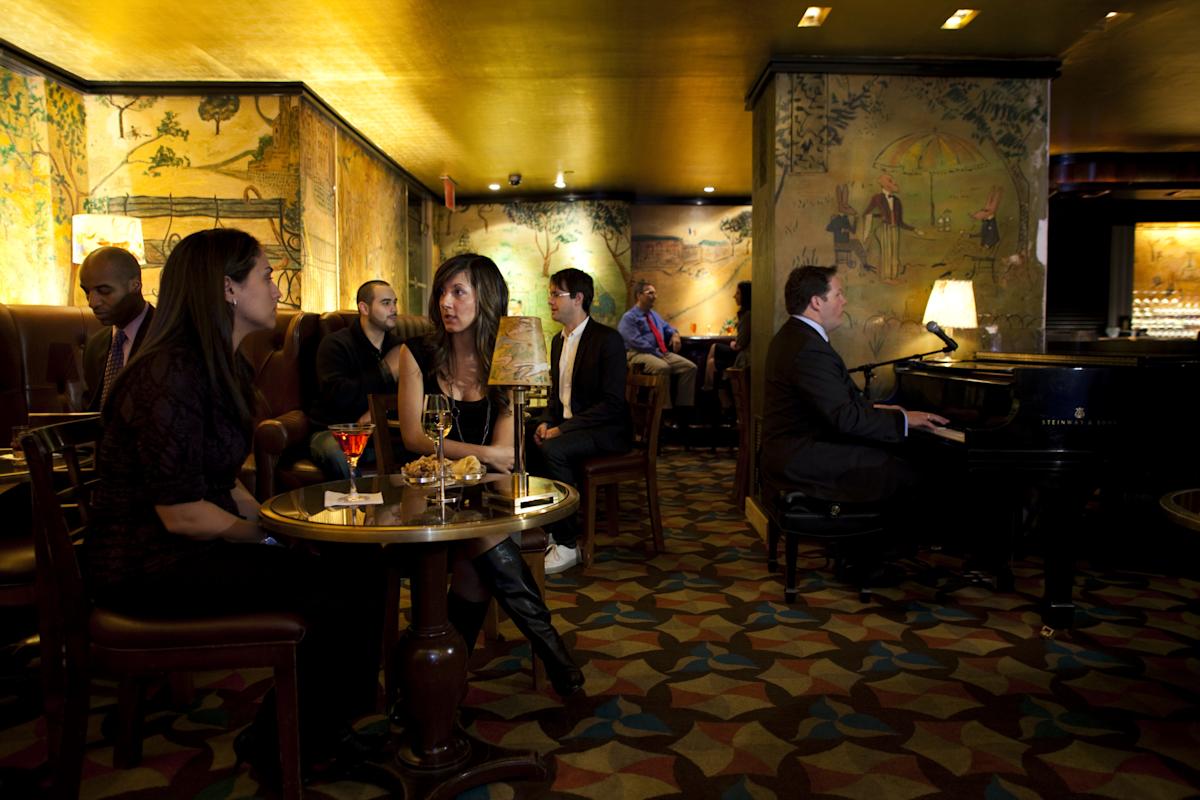 People and piano player in Bemelmans Bar at The Carlyle, A Rosewood Hotel, Upper East Side, NYC