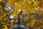Statue in Central Park, Manhattan, against fall foliage