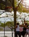 A group of people plays basketball in Astoria Park in Queens