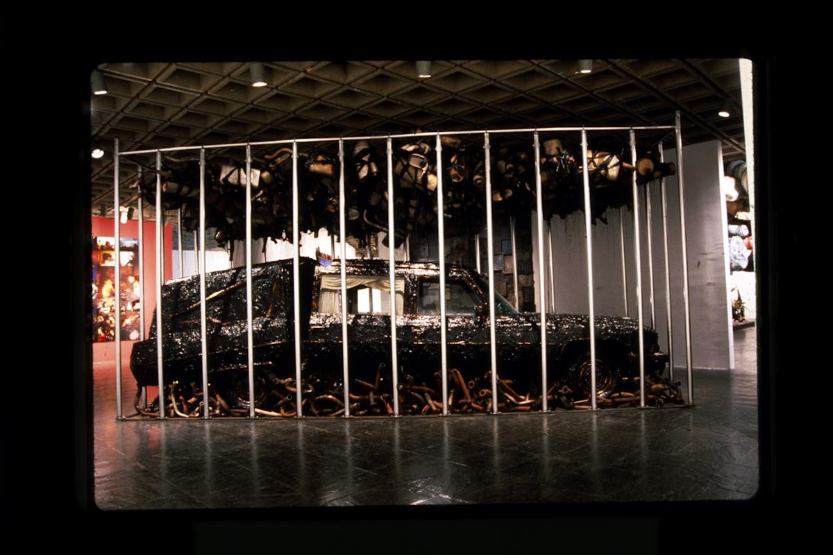Nari Ward, Peace Keeper, 1995. Hearse, grease, mufflers, and feathers, 144 x 116 x 264 in
(365.8 x 294.6 x 670.6 cm). Installation views: Whitney Museum of American Art, New York, 1995. Courtesy the artist, Lehmann Maupin, New York, Hong Kong, and Se
