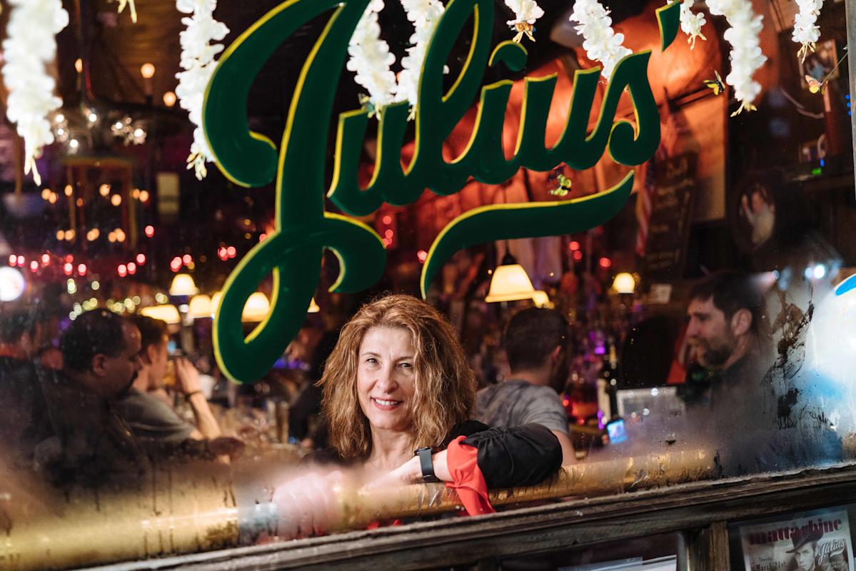 Person looking at the camera from inside of Julius, a bar in the West Village, Manhattan