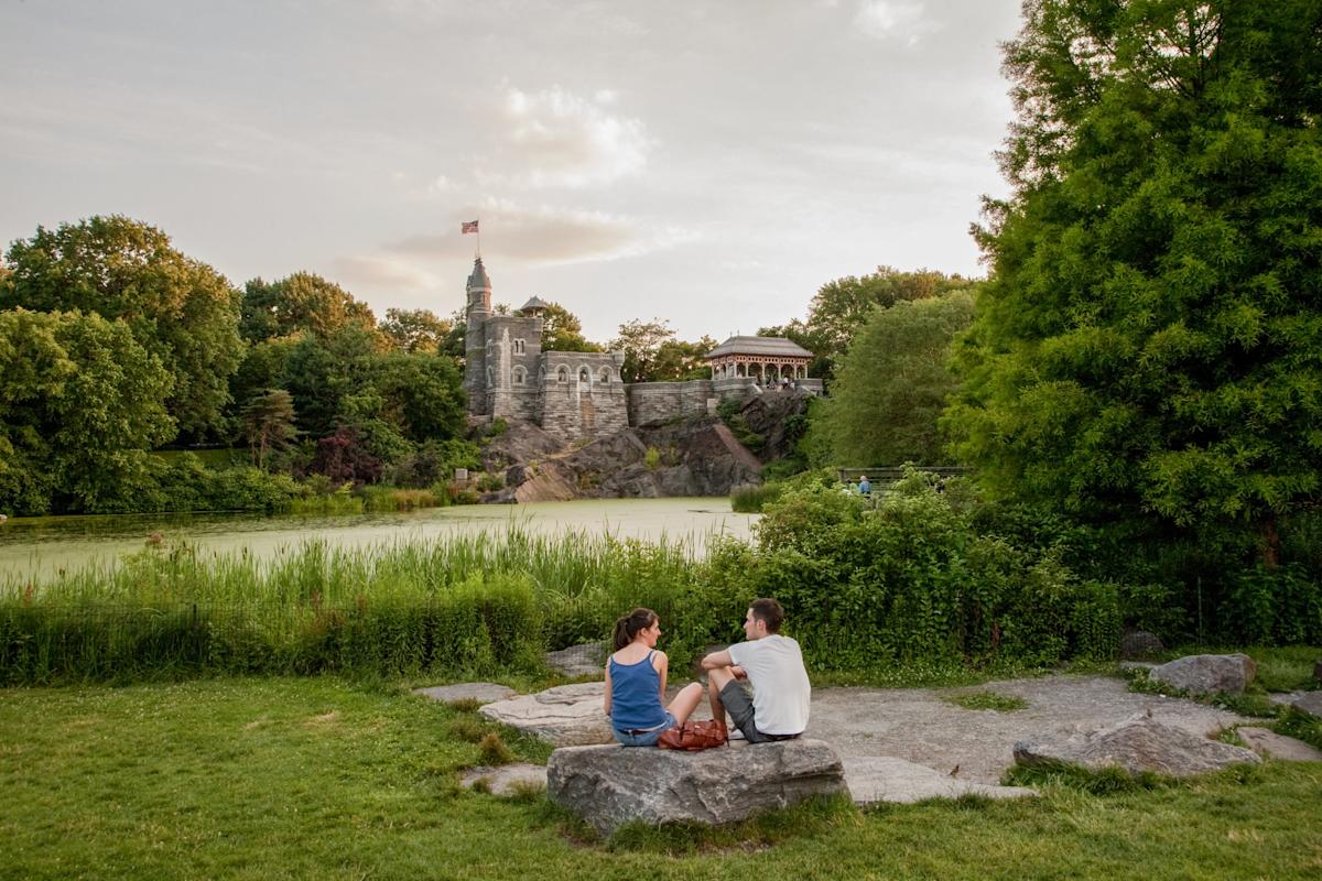 People seating in Central Park looking at Belvedere Castle in NYC