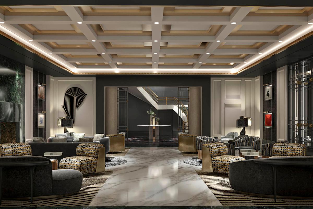 Luxurious hotel lobby with modern decor, marble floors, patterned rugs, contemporary furniture, geometric ceiling, and abstract wall art. Double doors at the back open to a staircase with gold railings.