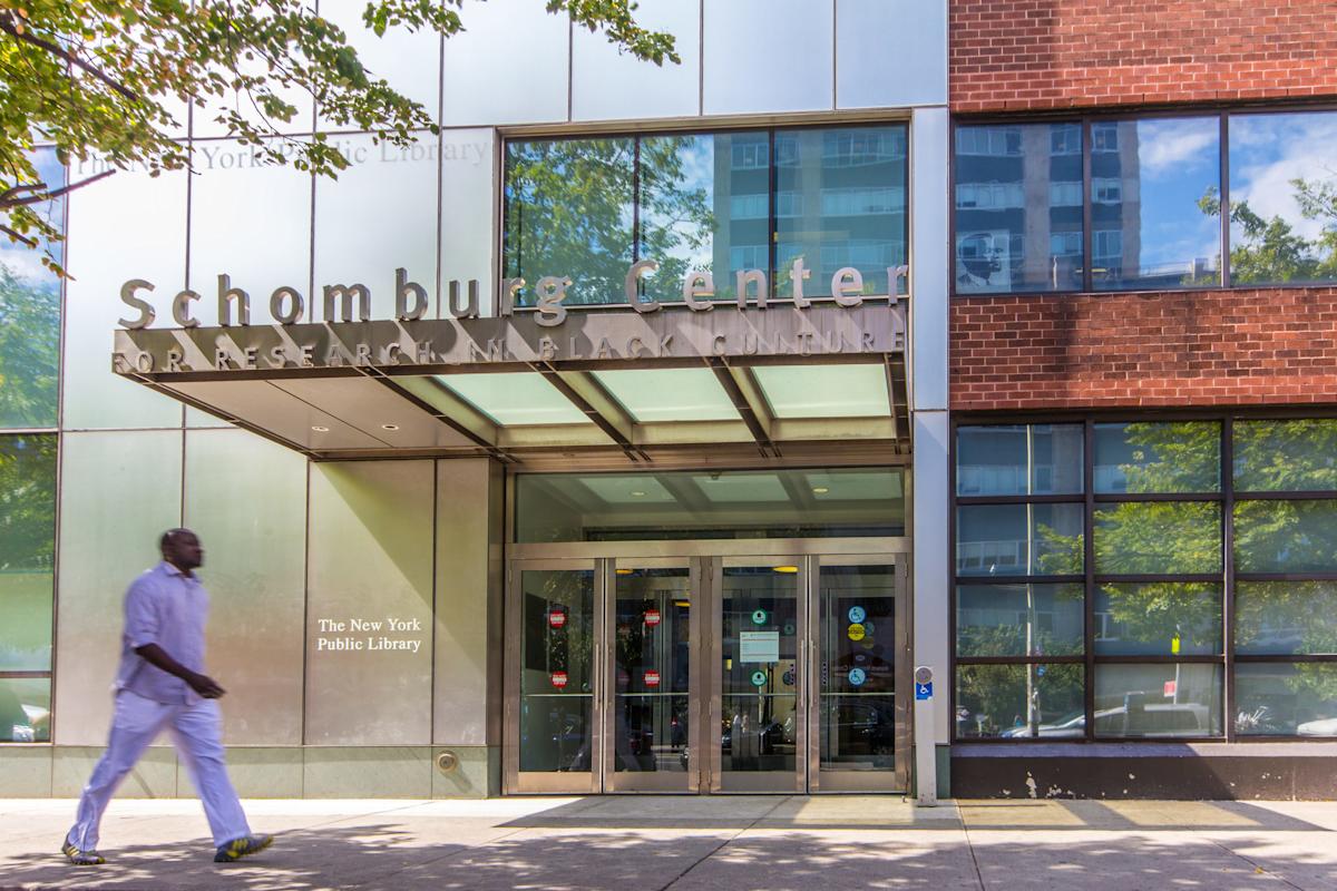 Person walking outside of Schomburg Center for Research in Black Culture, Harlem, NYC