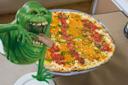 Slimer from Ghostbusters eating pizza at Joe and Pats