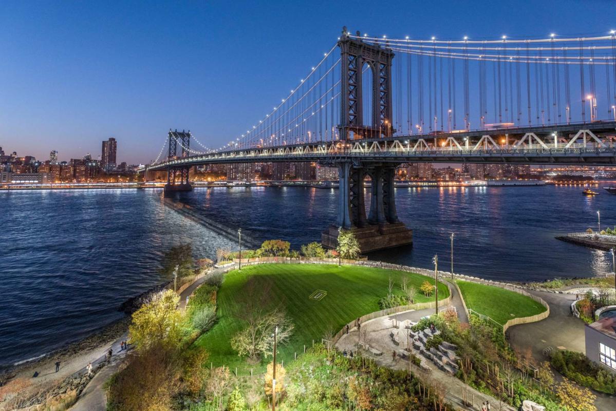 Manhattan Bridge Park at night with a view of the Manhattan skyline