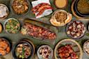 A vibrant and diverse array of Filipino dishes served on a banana leaf. Includes grilled pork belly, shrimp, vegetable stir-fry, and other traditional foods, creating a colorful and appetizing display.