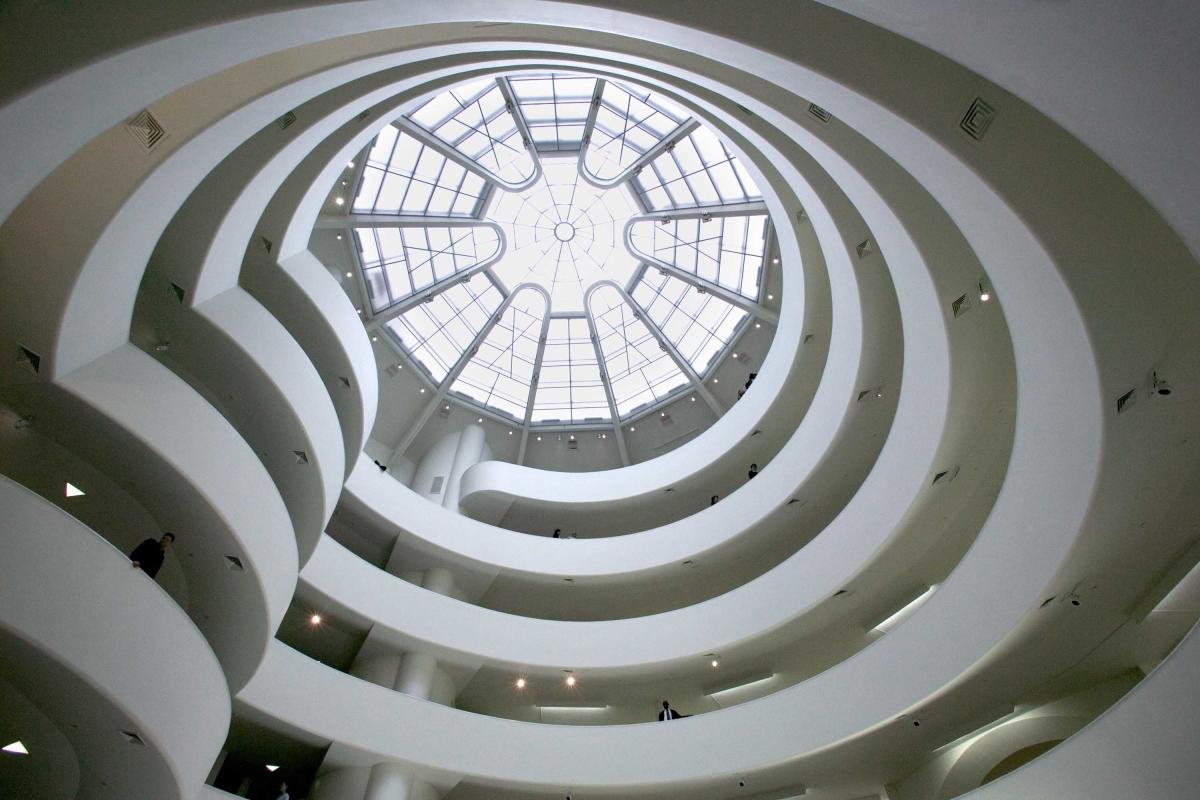 Inside of the Guggenheim Museum, Manhattan, New York City, looking up at the ceiling, with bright light coming through the skylight around the spiral staircase.