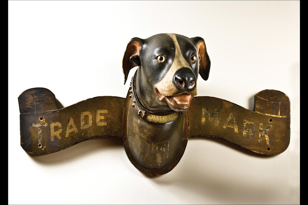 Dog Trade Sign
Arast unidenafied
Made for A.L. Kieselbach Paint Store
Brooklyn, New York
c. 1898
Paint on wood with leather and metal collar and glass eyes 16 x 38 x 17&quot;
Collecaon of Penny and Allan Katz
