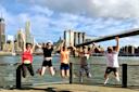 A group of people jump in front of the Brooklyn Bridge