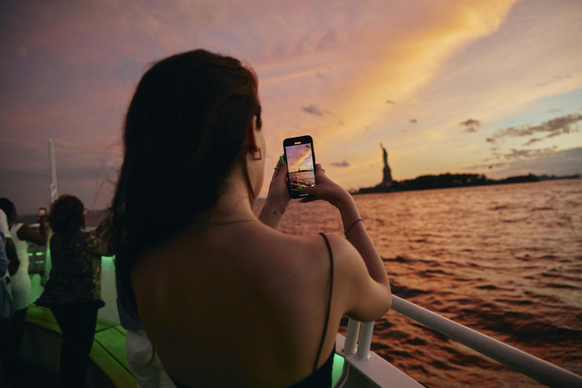 Person taking picture of Statue of Liberty from NYC Water Cruise