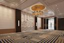 Elegant, spacious ballroom with patterned carpet, decorative wall paneling, and a large gold chandelier. Tall windows and modern wall lights enhance the sophisticated, modern art-deco design.