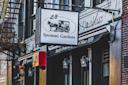 A street view of the L&B Spumoni Gardens storefront, featuring a hanging sign with a horse and cart graphic, and an awning reading "Family Owned and Operated Since 1939.