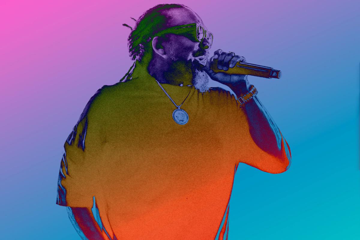 A man with braided hair and sunglasses holds a microphone while performing, wearing a pendant necklace and bracelet, set against a vibrant, colorful gradient background.