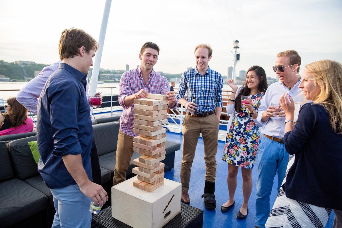 Adults playing an enlarged version of jenga on the Spirit of New Jersey 