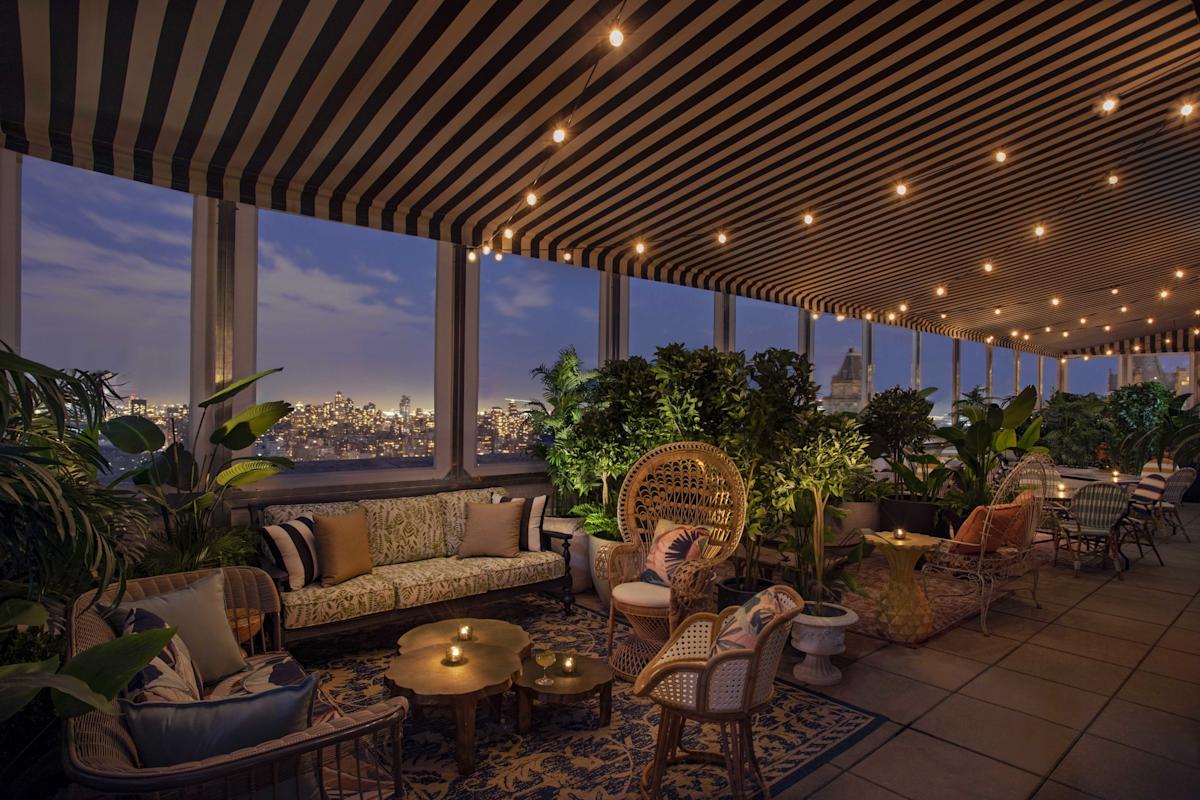 a living room filled with lots of furniture and plants.