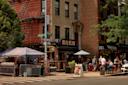 People walk in Tompkins Avenue in  Bed-Stuy, Bed-Vyne Brew in the background 