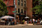 People walk in Tompkins Avenue in  Bed-Stuy, Bed-Vyne Brew in the background 