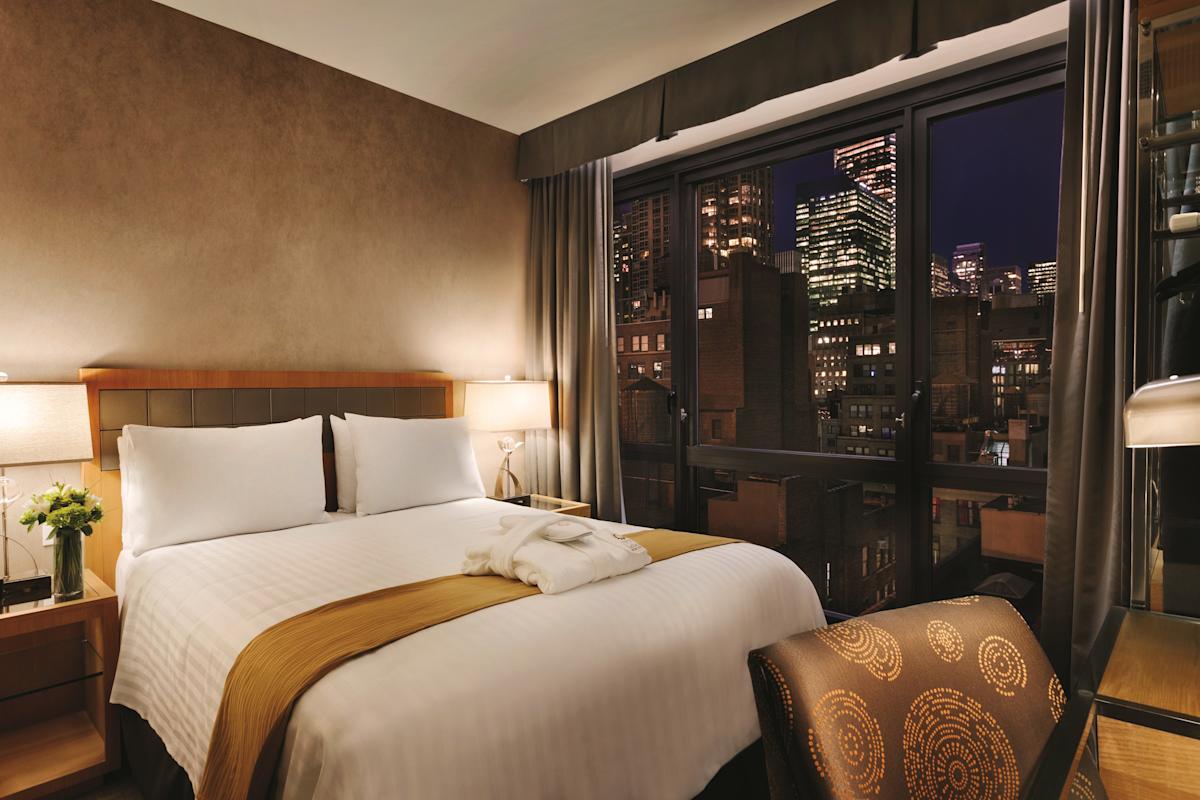 Queen bedroom with view of Manhattan at Executive Hotel LeSoleil in Midtown West