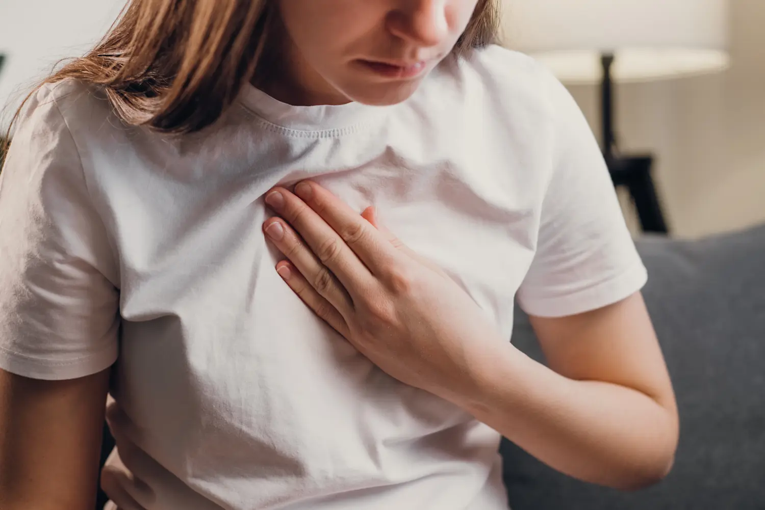 Woman experiencing shortness of breath holding chest
