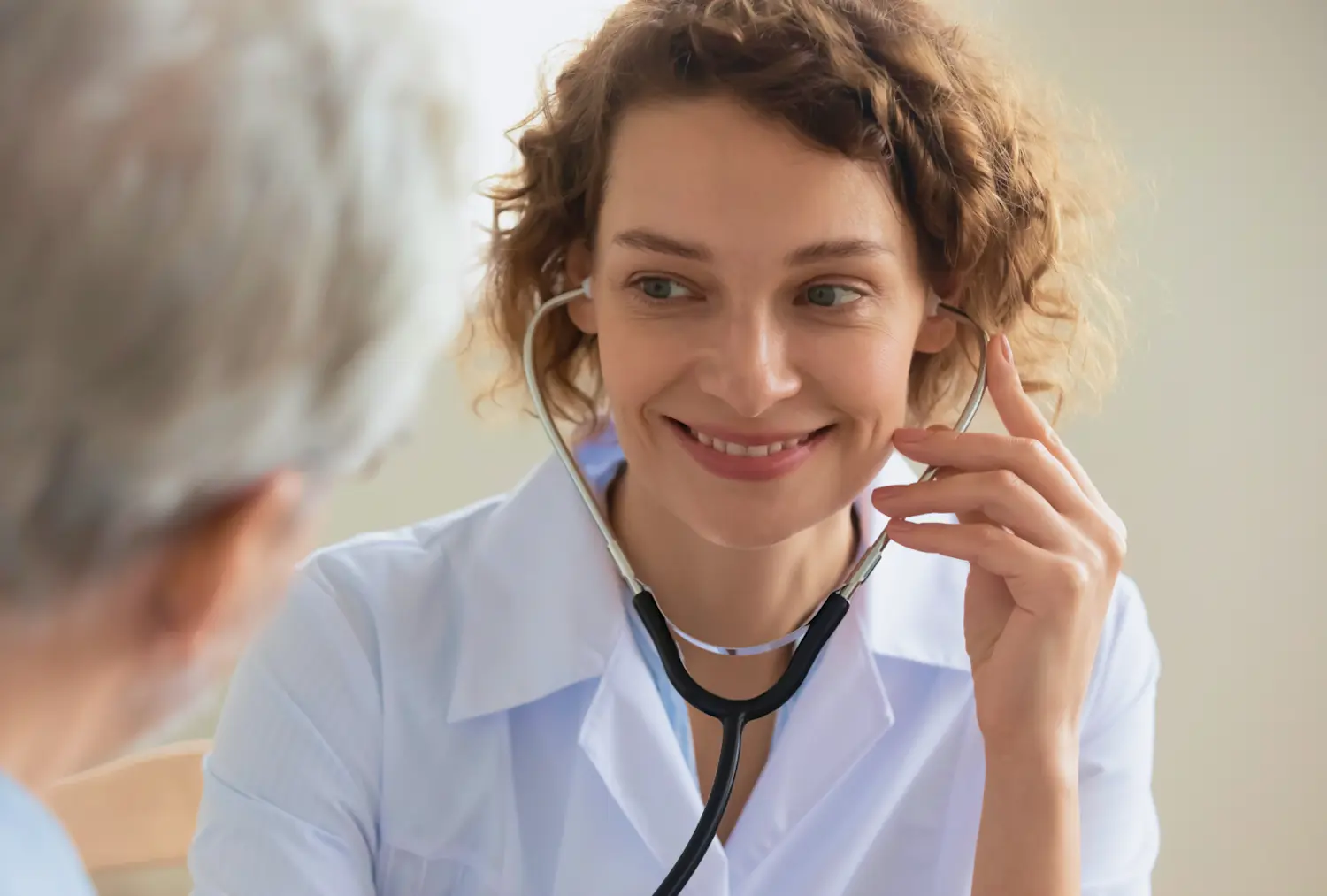 Female doctor with a stethoscope smiling to a patient