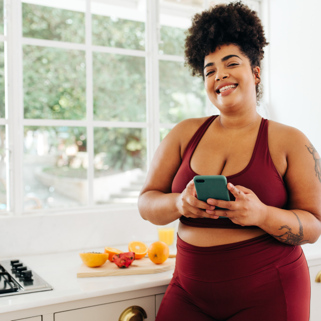 Woman in workout clothes preparing a healthy snack in her kitchen