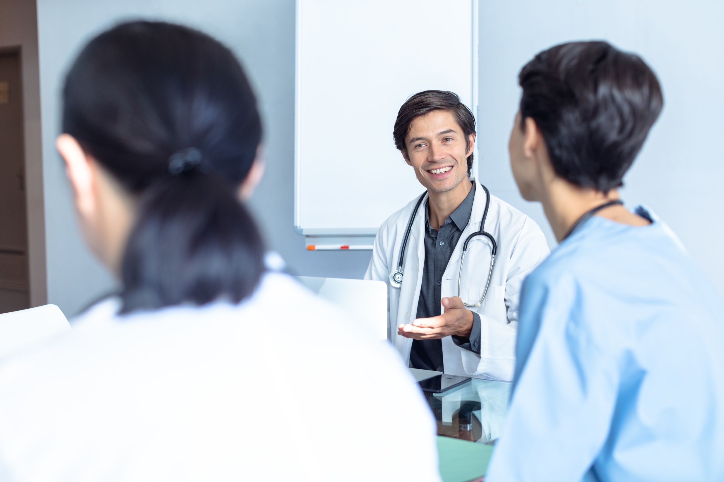 Happy doctor talking to people